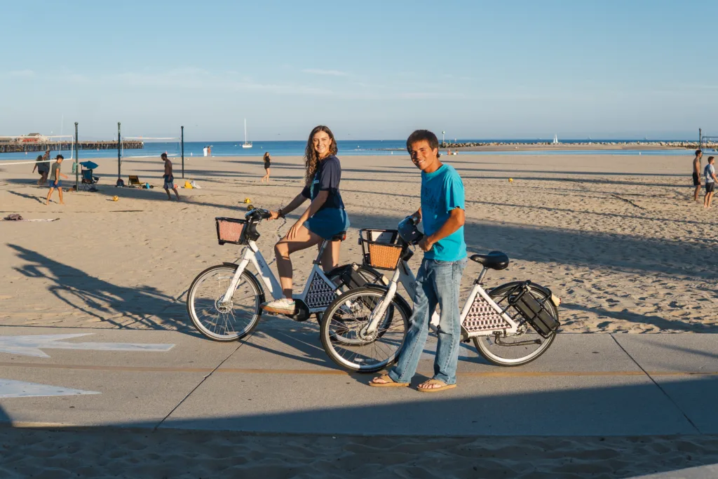 Woman and man riding bike share bikes on Santa Barbara's beach