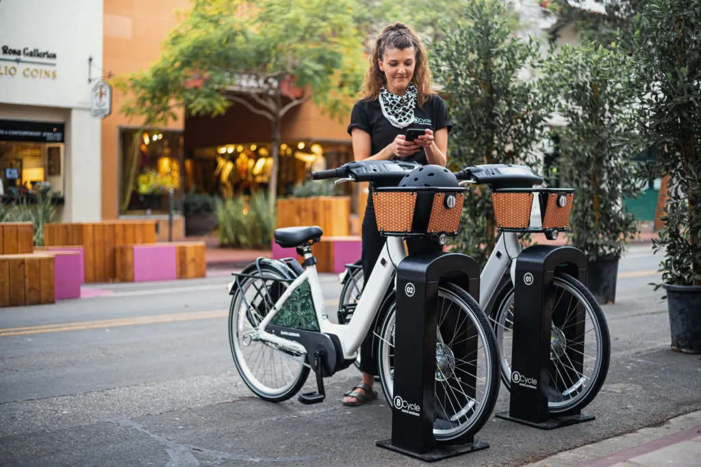 woman using her smart phone to purchase a bike share bicycle pass.

