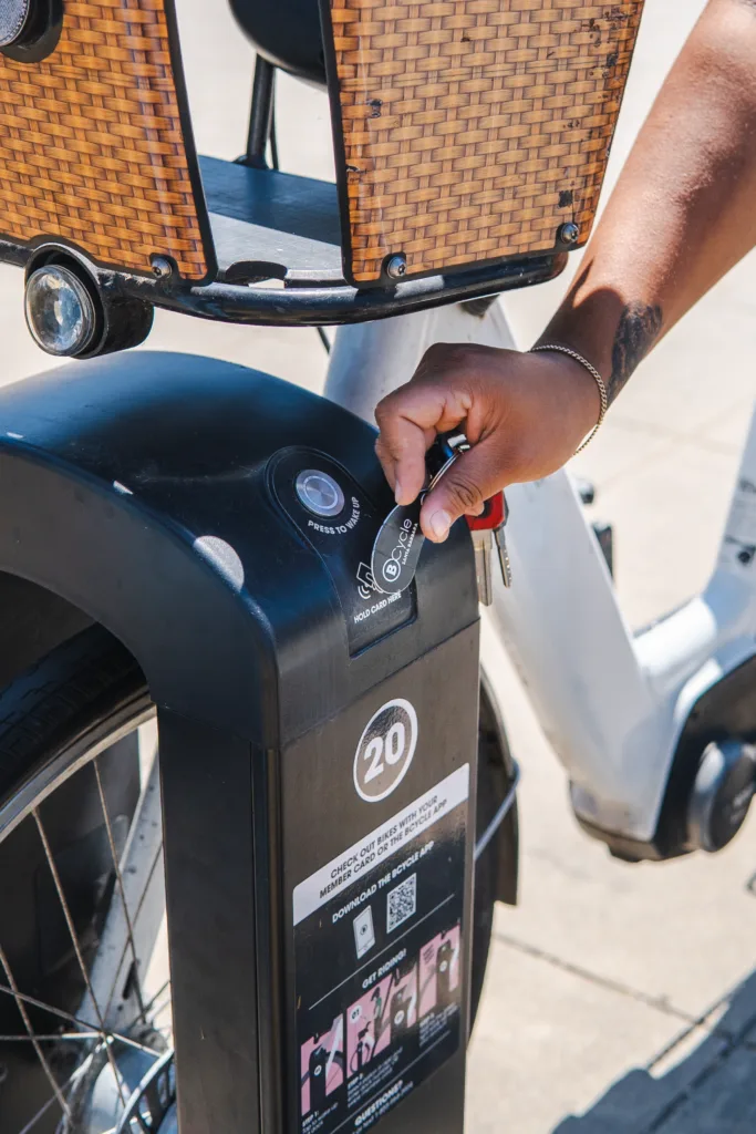 A woman using a membership FOB to check out a bike